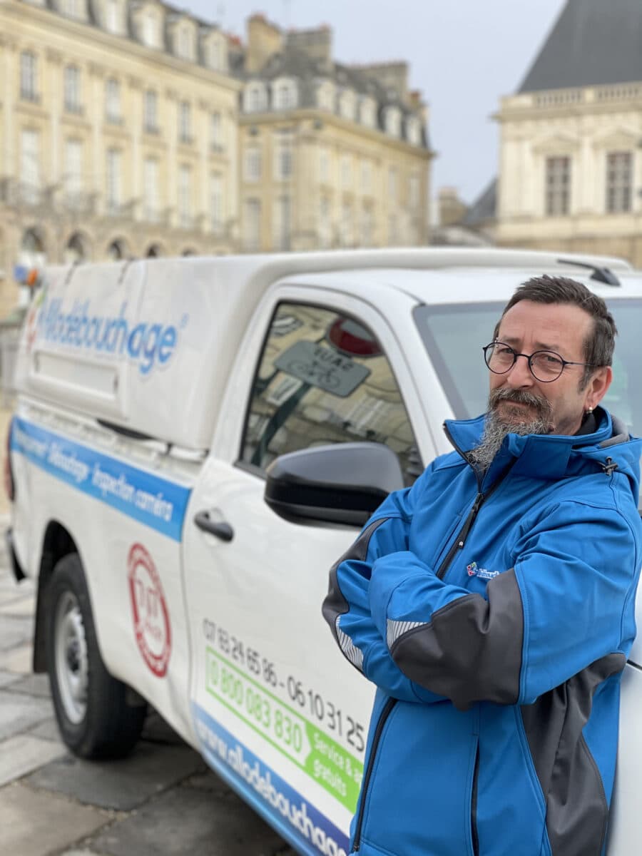 Technicien de débouchage de canalisation devant son camion d'intervention Rennes